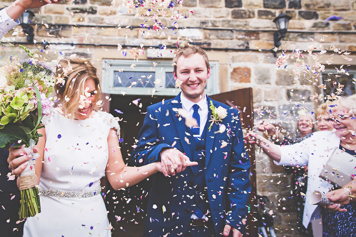 A newly wed couple having confetti thrown over them outside The Norfolk Arms